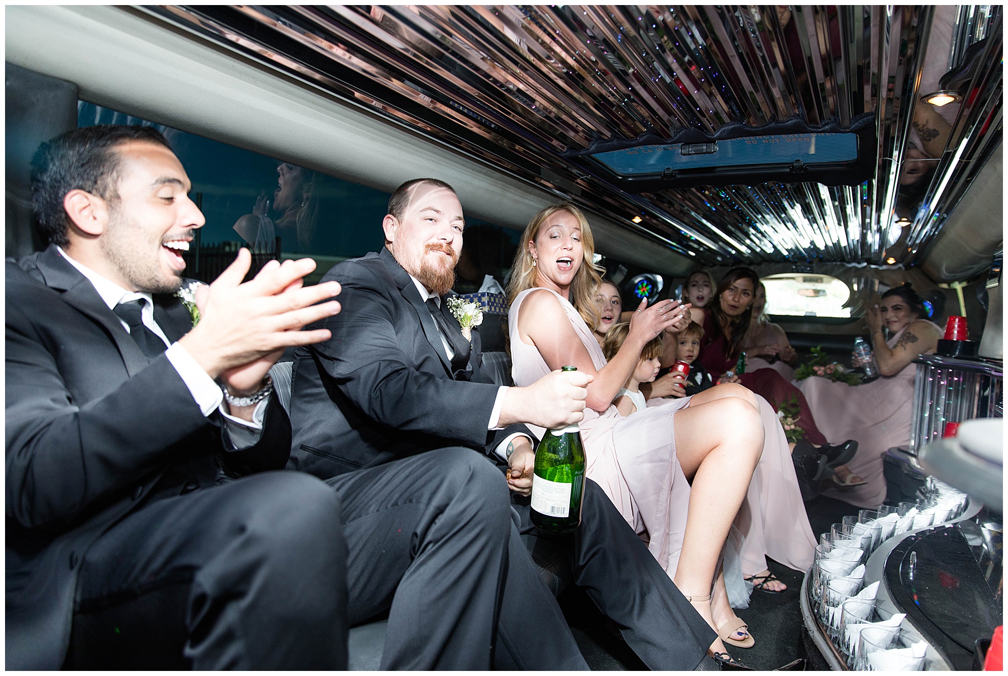 bridal party on party bus popping champagne