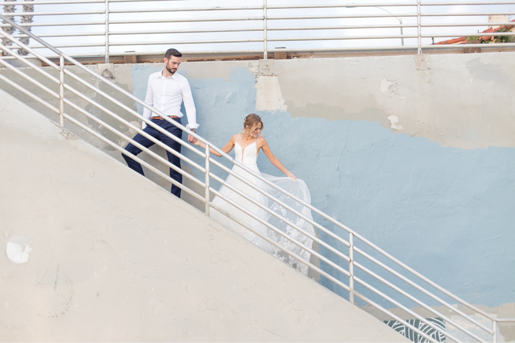 bride and groom walking up la jolla beach stairs