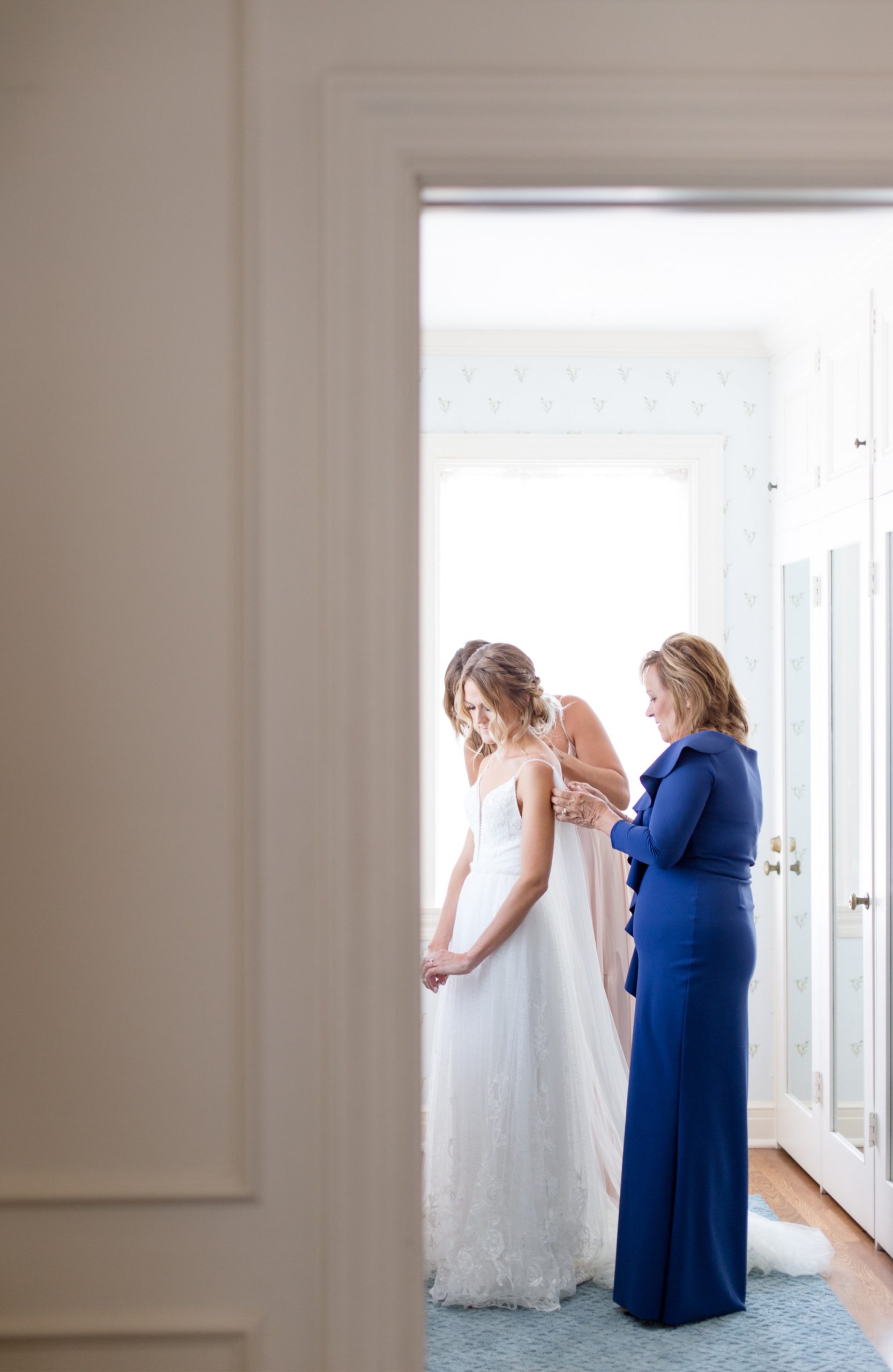 bride getting ready with mom and maid of honor