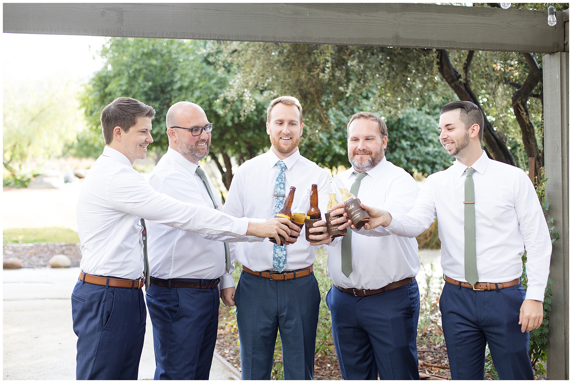 groom and groomsmen toasting with beers
