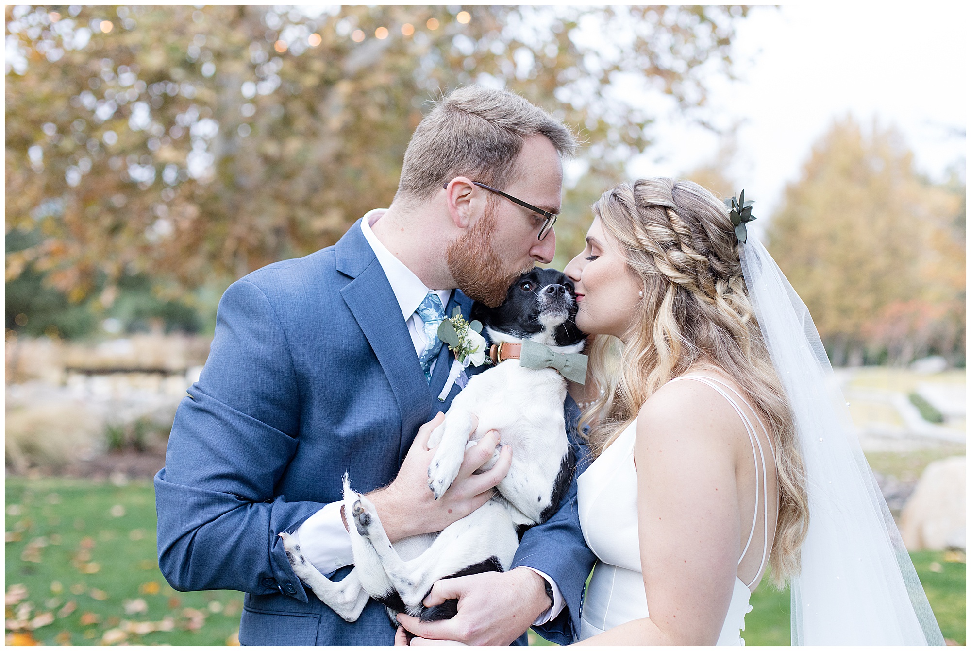 bride and groom kissing their dog