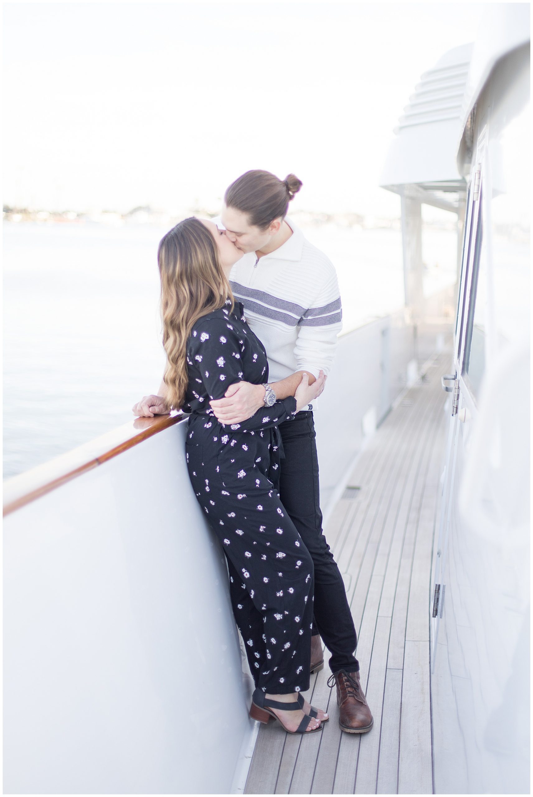 engaged couple kissing on yacht
