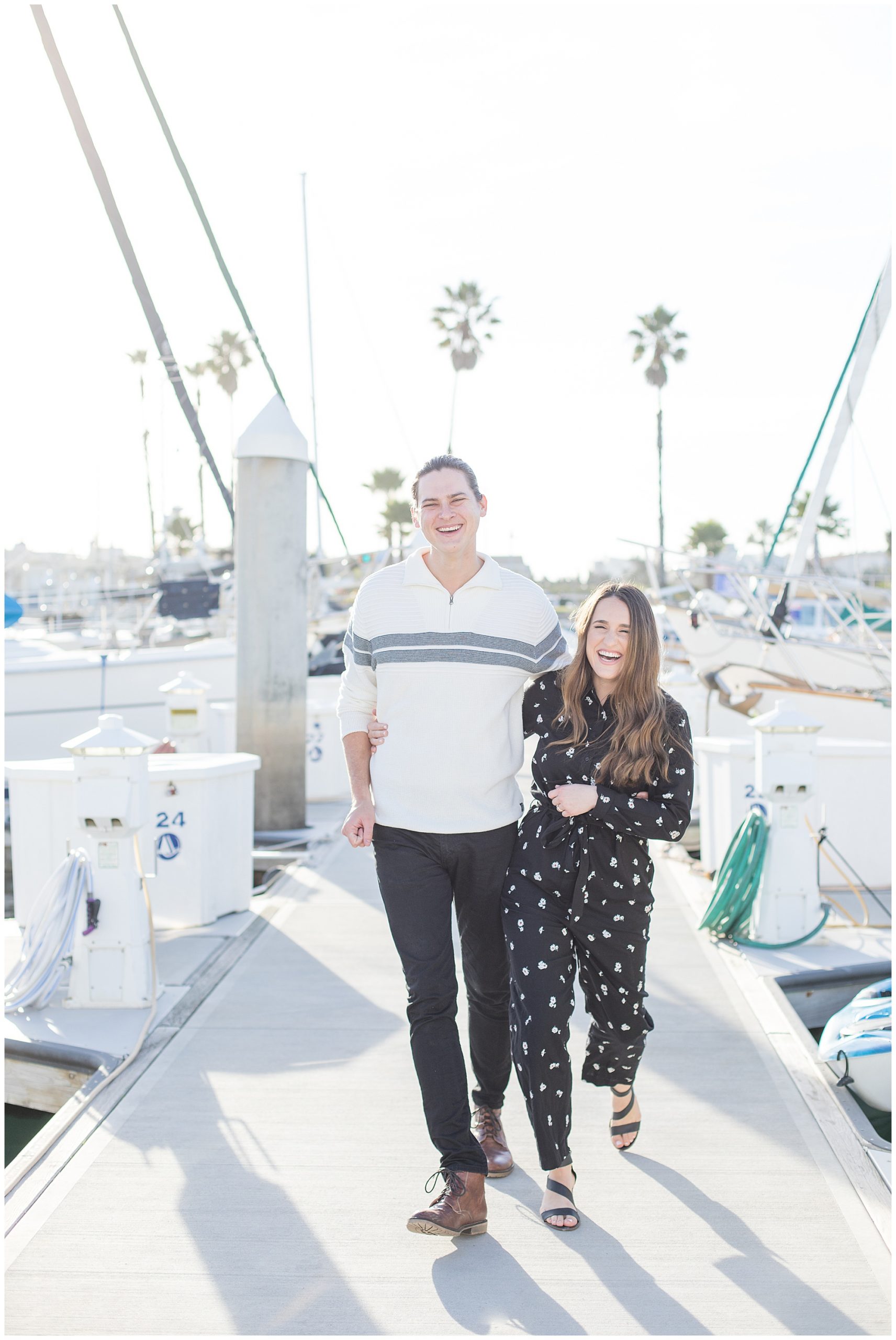 engagement photos on marina of engaged couple walking on dock