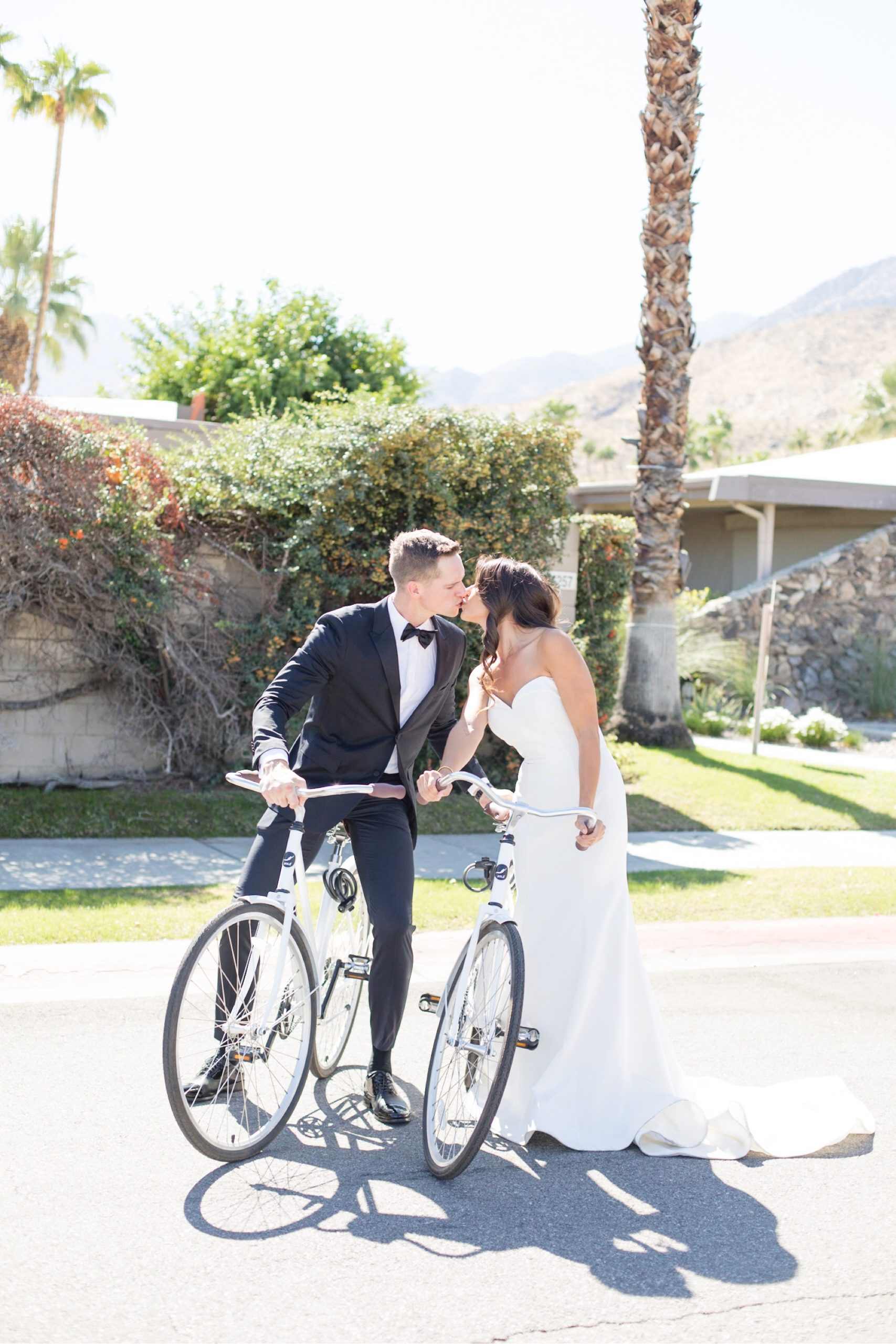 bride and groom kissing at palm springs wedding with bikes