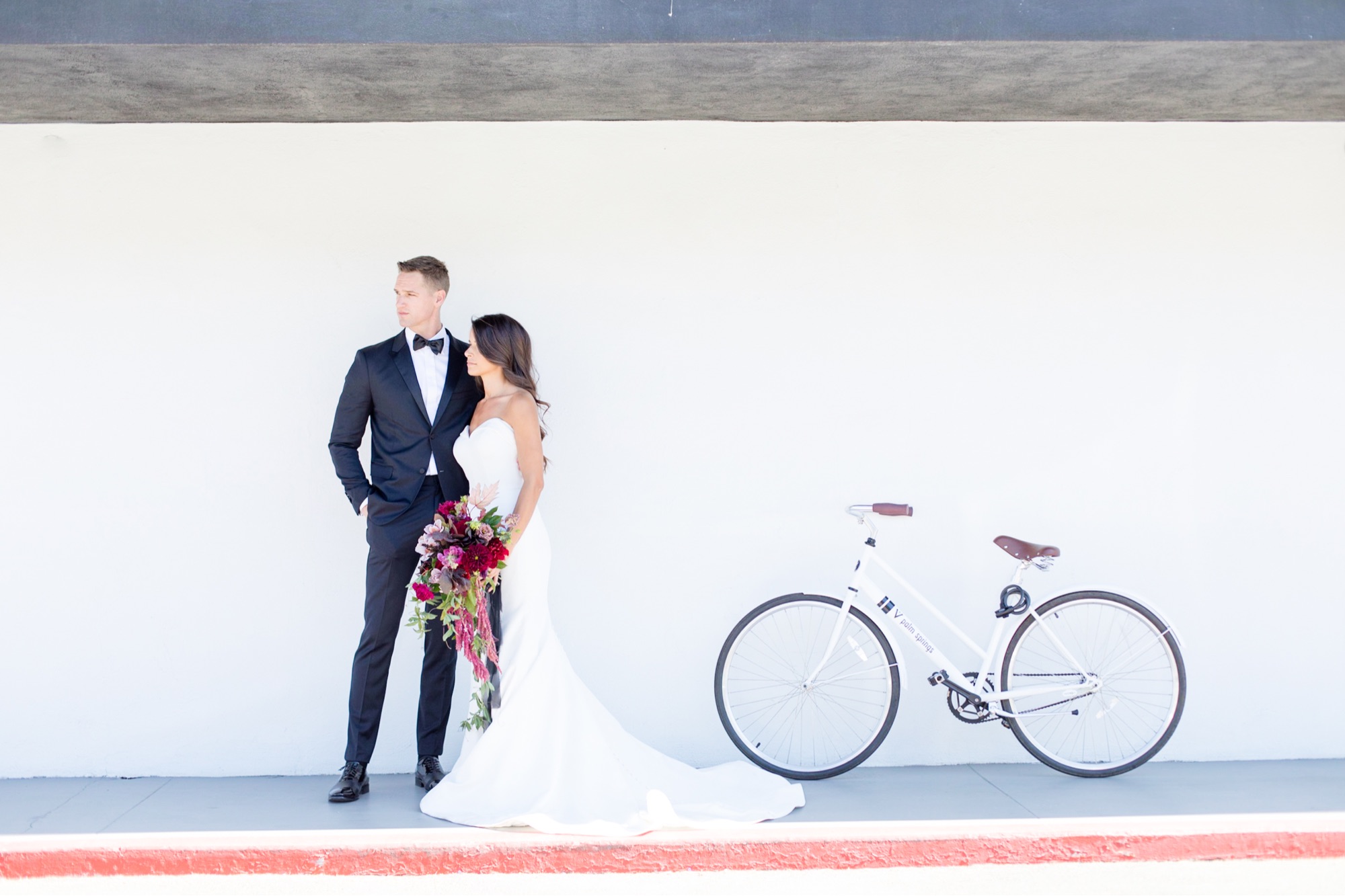 bride and groom posing with bike