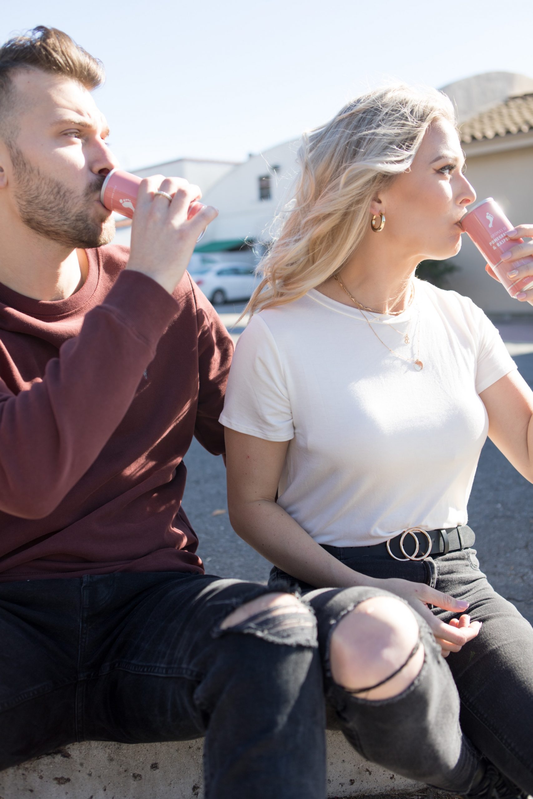 engaged couple drinking barefoot canned wine in front of taco bell