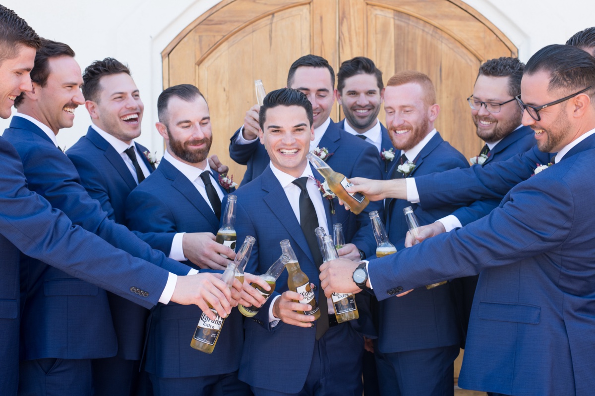 groomsmen and groom drinking coronas before wedding