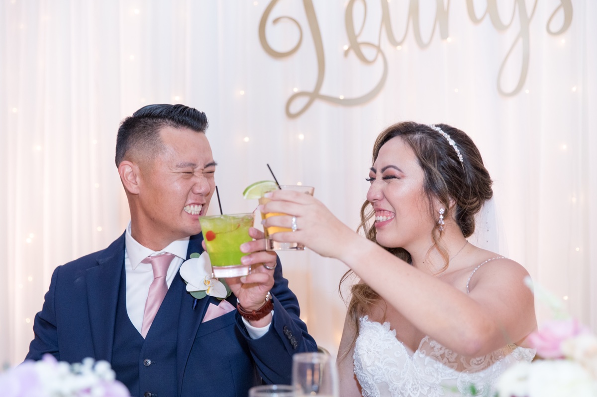 bride and groom cheersing at indoor ballroom wedding reception