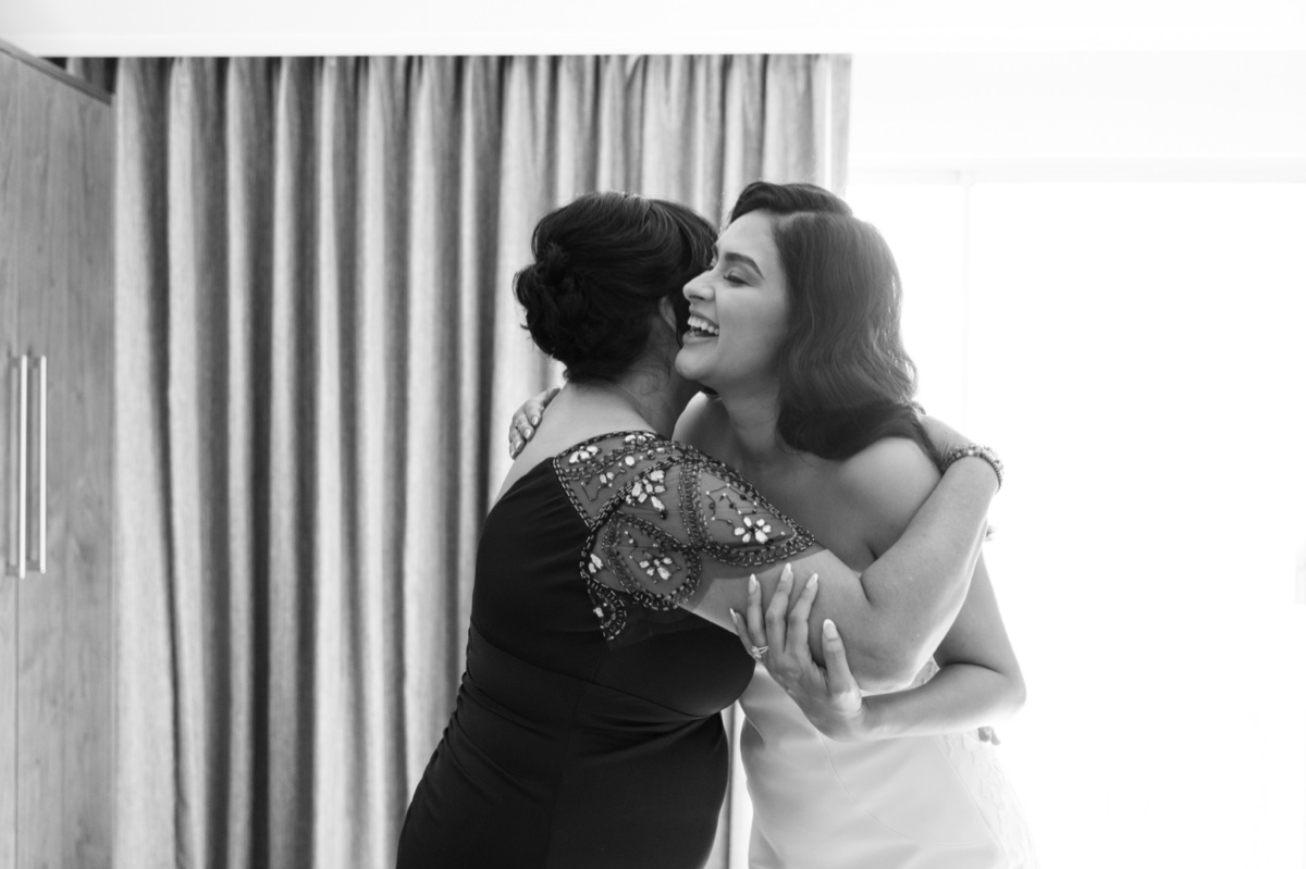 bride and mother of the bride hugging 