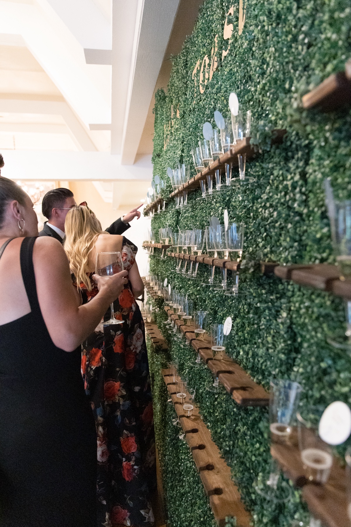 guests looking for their table numbers on the champagne wall