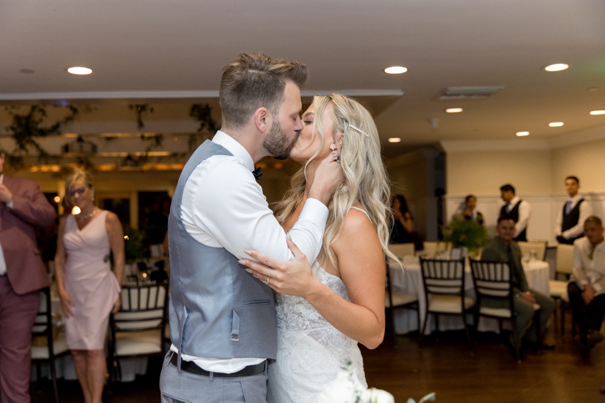 bride and groom kiss cake cutting