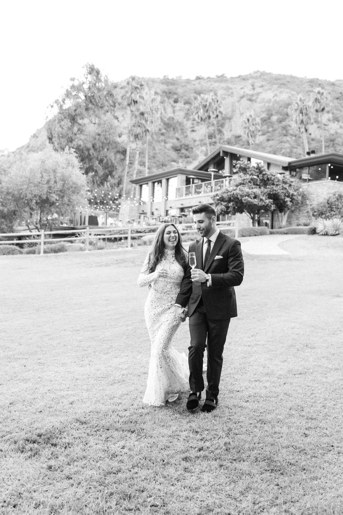 bride and groom walking into their ranch at laguna beach wedding cocktail hour with champagne