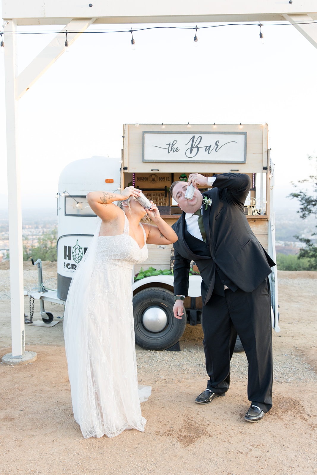 wedding mobile bar bride and groom shot gunning beers 