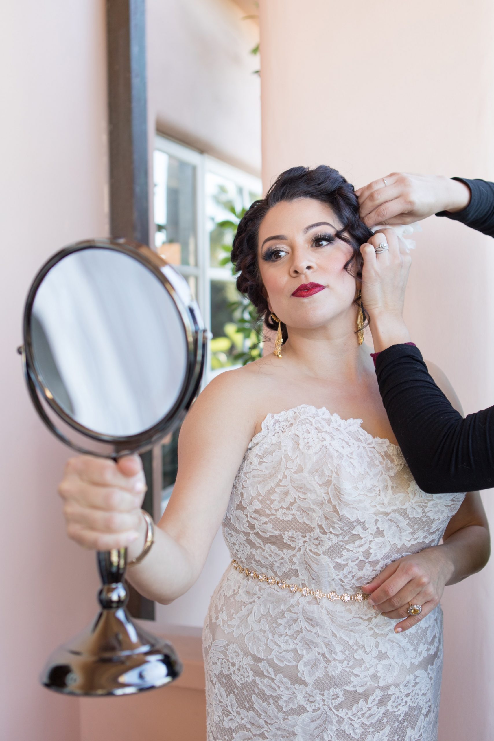 bride lookin in mirror while getting ready for her La Valencia Hotel makeup and hair by Sesentiraimme Artistry